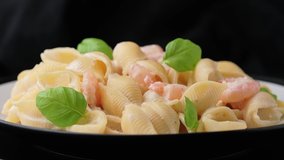 Italian conchiglie prawn, shrimp pasta in a creamy cheese sauce. rotating video.