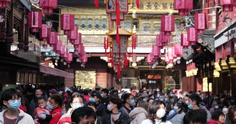 Shanghai.China-Feb.2021: crowded tourists in face mask to prevent coronavirus, walking in City God Temple during traditional Chinese new year