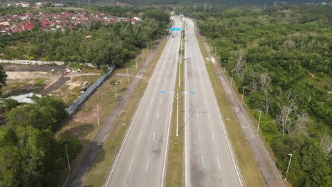 Aerial view of highway in Desa Pinggiran Putra, Putrajaya with a white car moving on the road.