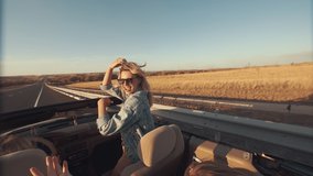 View from back seat as young women enjoy lifestyle during ride in convertible, women in sunglasses raise their hands, have fun and fool around. Ride in convertible on highway, sunset - Powered by Shutterstock - Get 15% off with code: PIKWIZARD15