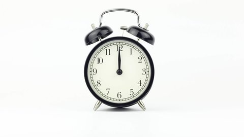 Classic alarm clock shows the time 12 o'clock on a white background. End of the day concept.
