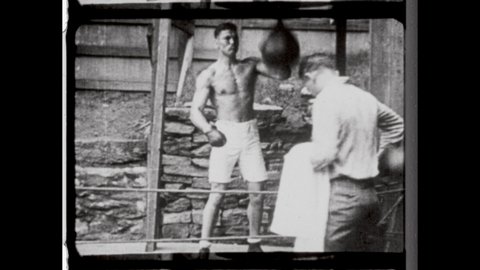 1920s Salt Lake City, UT. Prizefighter and Heavyweight Champ Jack Dempsey, or Kid Blackie, punching a speed bag. 4K Overscan of Vintage Archival 16mm Film Print