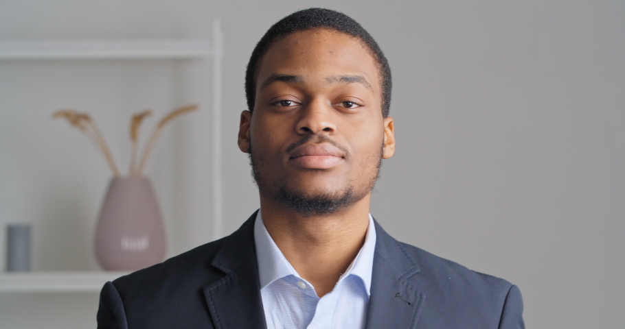 Portrait of afro american confident business man stylish ethnic guy groom preparing for wedding meeting in office wears expensive eligant black suit and blue shirt button up collar looking at camera