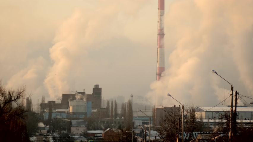 The smoke coming from the factories spreads over the city and turns into a thick smog. Production in the city. Environmental issues