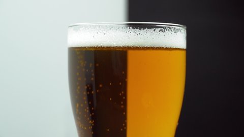 The glass is divided into two colors, black and white. Choose between light and unfiltered beer. Separation of colors and taste. Choice or opposition.