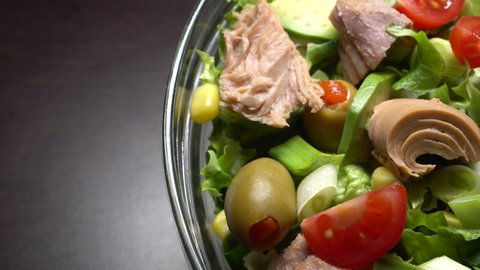  Tuna salad with lettuce, olives, spring onions, cherry tomato, avocado, corn and canned tuna. Pan Right. Close up.