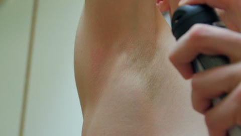 Man deodorant spray closeup in the bathroom