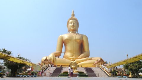 Ang-Thong, Thailand - Feb 2021 : Time lapse of Golden big Buddha at Wat Muang located in Ang-Thong province, Thailand. People come to pay respect to the large golden Buddha statue.