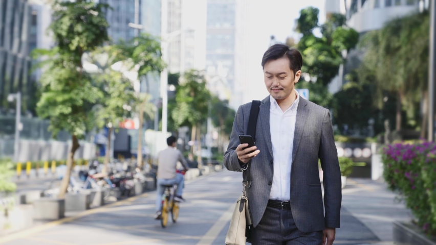 asian business man walking on street in modern city Royalty-Free Stock Footage #1068216386