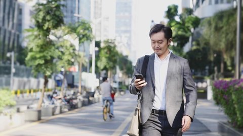 asian business man walking on street in modern city