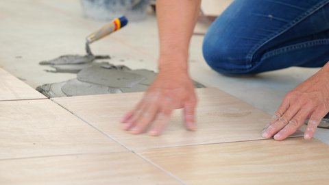 Installing ceramic floor tiles in construction site
