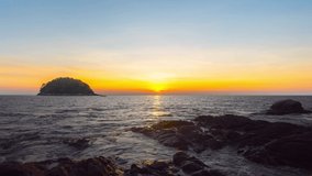 Nature video landscape view of sunset in sea. Rock beach and Island or mountain in sea. Golden sky sunset or sunrise