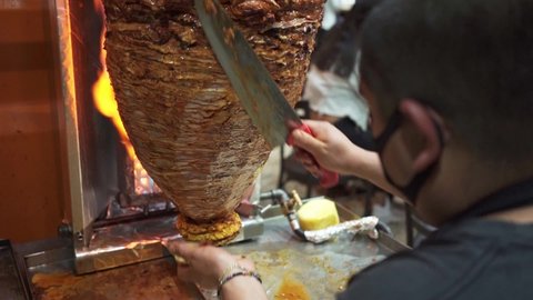 latin man preparing tacos on a grill