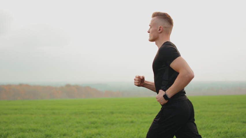 athlete running through field green grass Stock Footage Video (100%