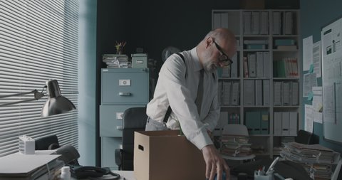 Employee packing his belongings and leaving the office, unemployment and economic crisis concept