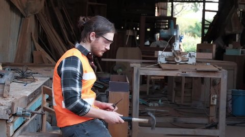 A young carpenter is working to order in his own wood factory. With peace of mind by using hand tools including saws, wood planers, hammers, and more. 