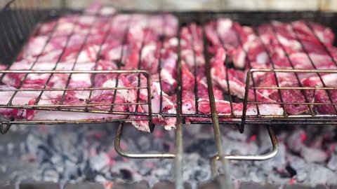 Lamb ribs cooked over an open fire, close-up in 4K. Lamb chops Grilling Barbecue, BBQ Originally made from lamb. Wire rack for roast lamb in the grill racks. The concept of traditional food on fire