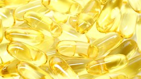 4K closeup Omega 3 fish oil pills background, vitamin E natural capsules texture