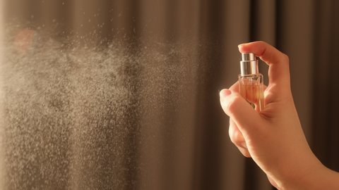 Hand spraying dust perfume, Slow motion. Applies perfume. Spraying fragrance with scent.