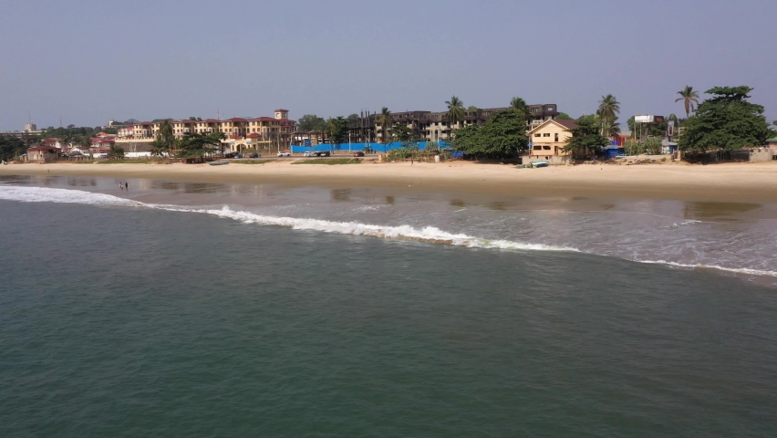 Aerial over ocean to beach Freetown Sierra Leone. Sierra Leone on the coast of west Africa is a nation that suffers with extreme poverty and hunger. Tropical climate, environment.