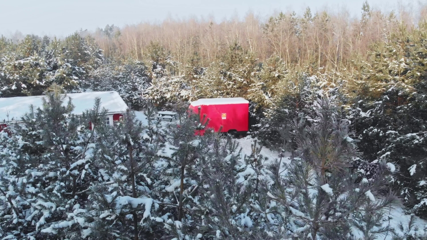 Drone shot of a snowed log house in a forest of Norway.