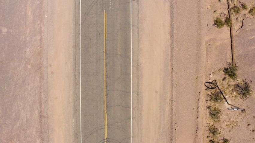 Top down view of route 66 as car passes highway marker. Drone.