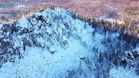 Aerial video from a drone overlooking a wonderful winter landscape in the Ural Mountains. View of the top of the Ufa peak and brave tourists in the sun. Aygir, Republic of Bashkortostan, Russia. 