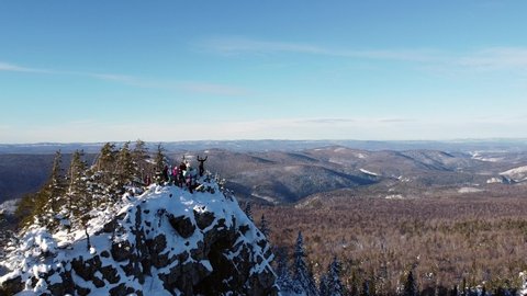 Aerial video from a drone overlooking a wonderful winter landscape in the Ural Mountains. View of the top of the Ufa peak and brave tourists in the sun. Aygir, Republic of Bashkortostan, Russia. 