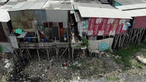 NORTH JAKARTA, PLUIT PENJARINGAN, INDONESIA - FEBRUARY 24, 2021: Aerial view of shanties in slum area of Pluit water reservoir that suffers from trash problems for years, but now is being cleaned.