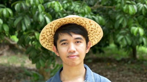 Young Asian farmer holding rambutan on his farm in Thailand