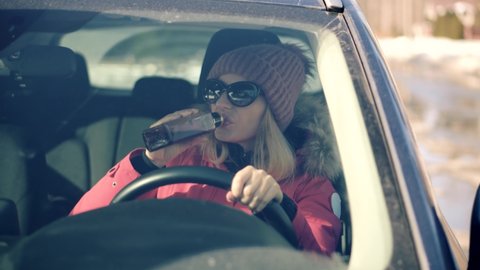 Drunk Driving Sitting On Car.Tired Woman Illegal Vehicle Driving. Drunken Drive Risk Car Accident.Holding Alcohol Bottle In Car. Dangerous On Road Drunk Driving. Stress Unlawful Intoxicated Drive Auto