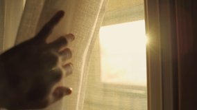 Hand reaches towards a window lit by sunlight - moves curtain to reveal the sun. Sunrise or sunset behind the window. Slow motion move to peek outside. Symbol of hope positivity and energy - Powered by Shutterstock - Get 15% off with code: PIKWIZARD15