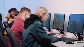 A group of programmers a man and young women work together and discuss the work. Work online. 4k video.