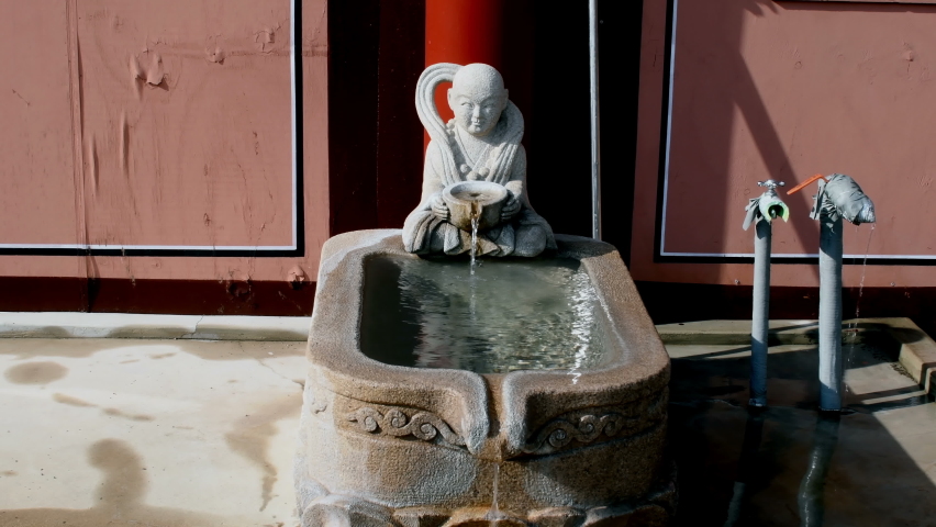 Water flowing in stone carved water cistern and public drinking fountain at Buddhist temple in Yeongcheon, South Korea.