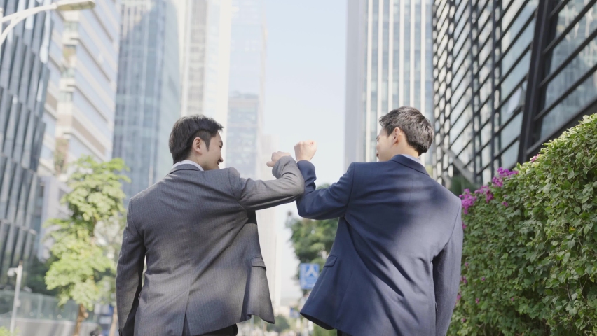 rear view of two asian businessmen talking while walking on street in modern city Royalty-Free Stock Footage #1068275957