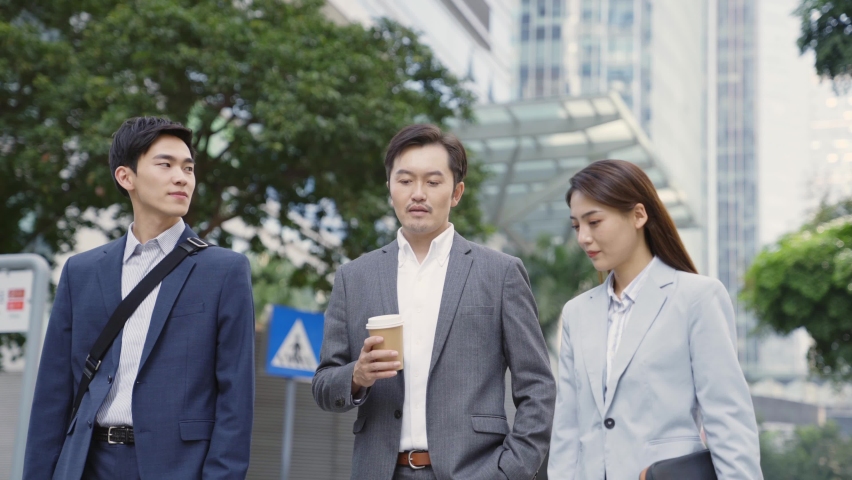 three asian business associates walking talking on street in modern city Royalty-Free Stock Footage #1068275978