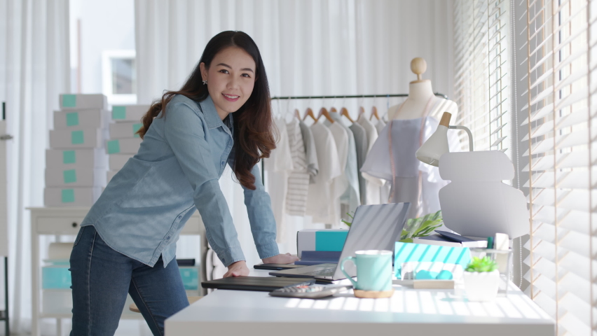 Portrait young attractive asia female owner startup business look at camera work happy with box at home prepare parcel delivery in sme supply chain, procurement, omnichannel commerce online concept. | Shutterstock HD Video #1068280355