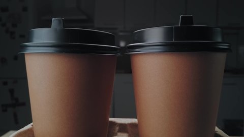 Two crafting paper coffee cups for takeaway extreme close-up rotating. Slow motion, slider camera move