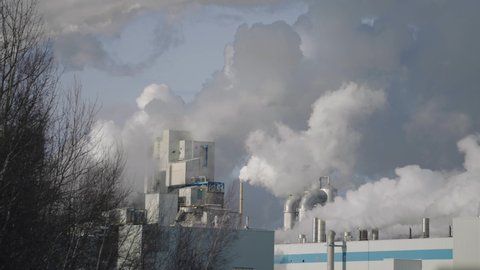 Chimney Stacks Of Paper Mill Releasing Thick Smoke At Daytime In Windsor, Quebec, Canada. - wide shot