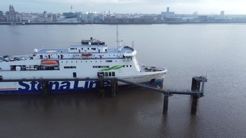 Wirral , Liverpool , United Kingdom (UK) - 02 07 2021: Stena Line freight ship loading cargo from Wirral terminal Liverpool aerial view tracking Mersey ferry
