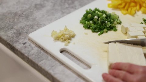 Panning Shot Of Woman Dicing Paneer In Slow Motion.