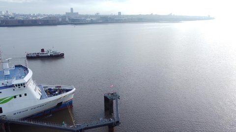 Wirral , Liverpool , United Kingdom (UK) - 02 06 2021: Aerial view following Mersey commuter passenger ferry in shimmering river to Woodside station Birkenhead