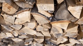 Stacked birch and pine firewood in the warehouse. Video. Close-up of natural wood as fuel, ready to be ignited.