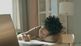 African American Black kid boy doing his homework or having a video call with class and teacher. Distance learning from home during isolation. Shot with 2x anamorphic lens