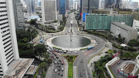 JAKARTA, INDONESIA - FEBRUARY 24, 2021: Cinematic aerial view of Selamat Datang monument statue or Welcome monument of Jakarta at Bundaran Hotel Indonesia during the COVID-19 pandemic.