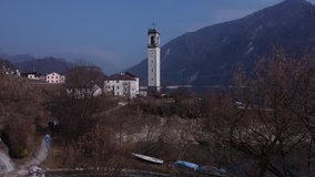 Bell tower of Church, lake and mountains, Italy, drone aerial shot.
