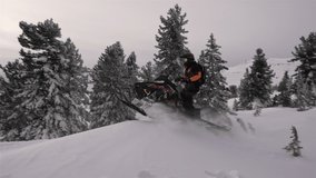 SLOW MOTION: video footage of jumping snowmobilers at sunset. the snowmobile flies through the air and creates large and beautiful swirls of snow. ProRes 422. HD 500fps