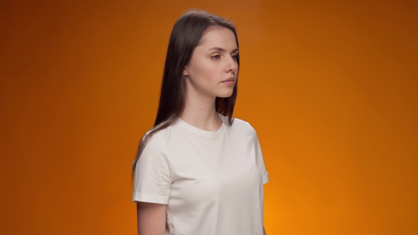 Young woman announcing something using loudspeaker against yellow background