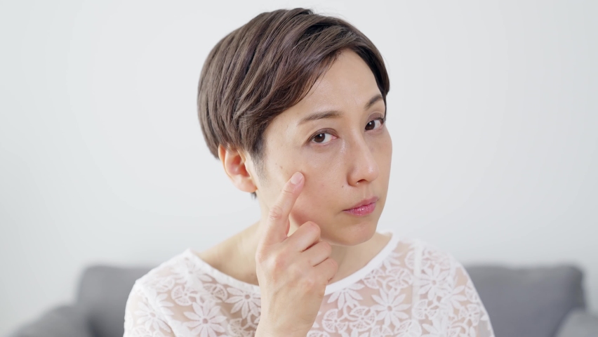 Middle aged Asian woman worrying about her facial skin. Rough skin. Beauty concept. Skin care. Royalty-Free Stock Footage #1068316985
