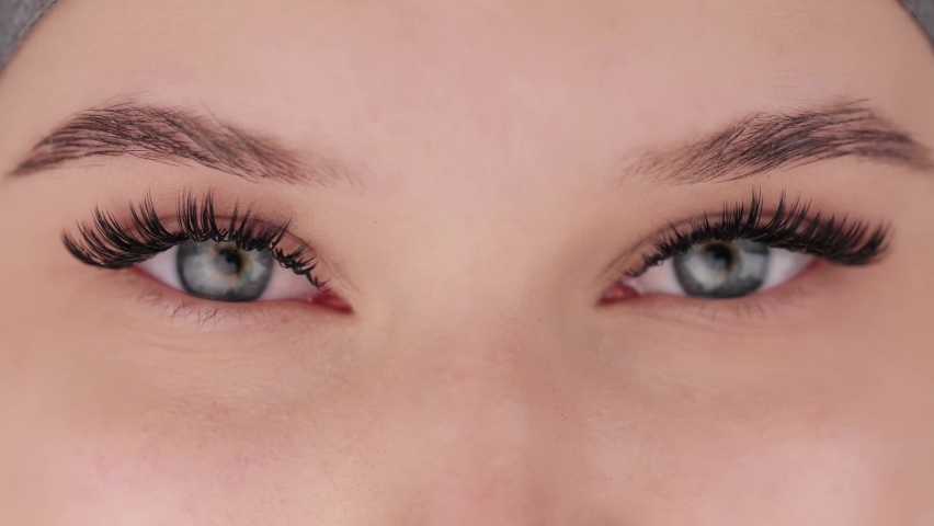 Close up portrait of female eyes after eyelash extension procedure. Young girl open eyes with fake eyelashes. Eyelashes extensions close up. | Shutterstock HD Video #1068320861